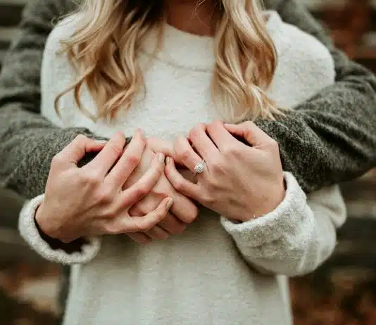 Un couple avec une bague de fiançailles à la main