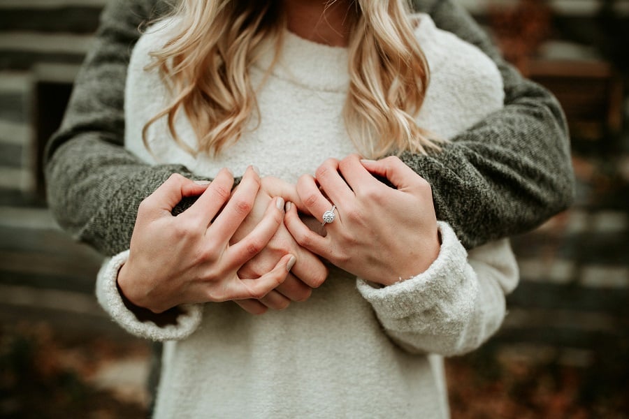 Un couple avec une bague de fiançailles à la main
