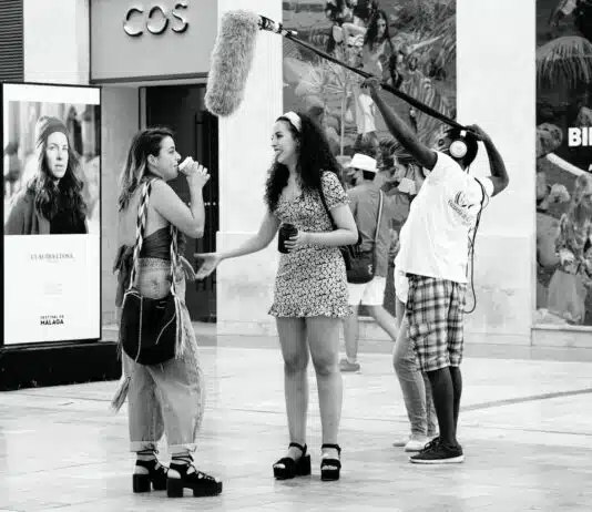 woman in black and white polka dot sleeveless dress holding black and white stick