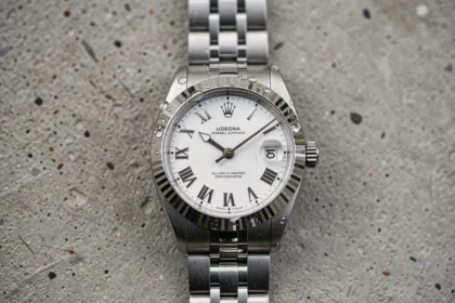 Rolex Datejust 36 posée sur béton brossé, cadran blanc avec chiffres romains et bracelet jubilé en acier inoxydable