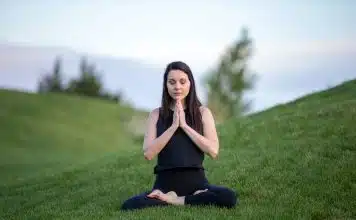 Yoga débutant : bienfaits surprenants pour votre santé woman in black tank top and black pants sitting on green grass field during daytime